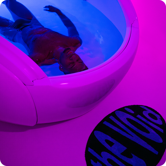 Pessoa flutuando dentro do POD VOID ZERO com luzes coloridas